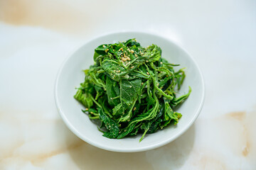 접시에 담긴 한국 전통 반찬 뽕잎 무침 요리