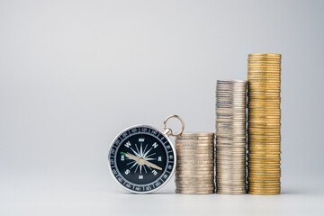 A compass and stacked coins representing guidance, direction, and steady financial growth, symbolizing a journey toward wealth and financial stability