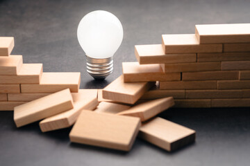 A light bulb shining through a broken wooden wall symbolizes the path of innovation, turning challenges into opportunities and revealing new directions