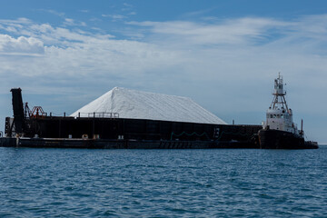 Tugboat pushing a barge loaded with salt, illustrating industrial transportation in baja california sur, mexico