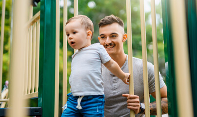 father with child boy on a playground having fun together