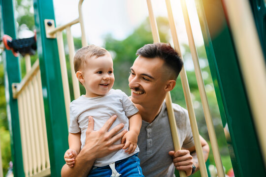 father with child boy on a playground having fun together - Powered by Adobe