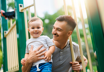 father with child boy on a playground having fun together