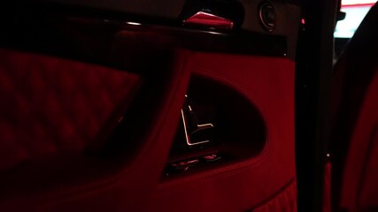 Interior of luxury vehicle featuring plush red upholstery and sleek metallic accents, showcasing modern design elements and high-end craftsmanship in an elegant atmosphere
