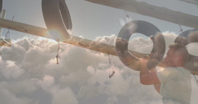 Climbing athlete wearing workout gear pulling through tire on chains at obstacle course, copy space