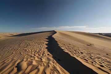 Sand dunes under blue sky with gentle shadows, no footprints visible