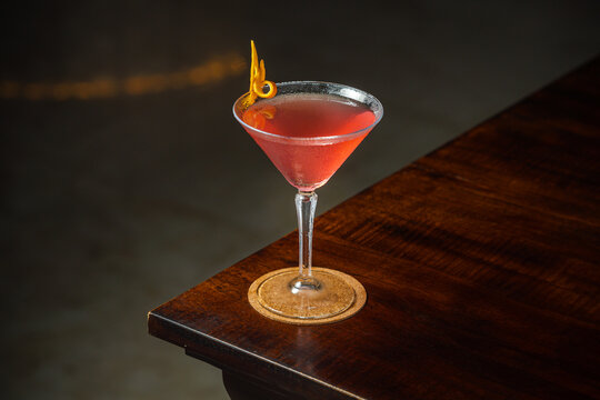 Cosmopolitan cocktails with orange garnish. served on the table.
