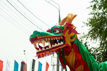 Chinese dragon head with ribbons at street celebration procession