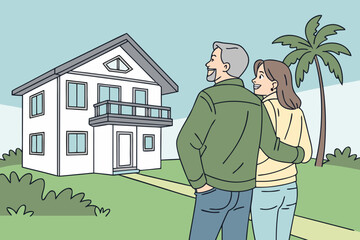 senior couple walking in front of house