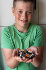Smiling boy offering halloween candy in his hands