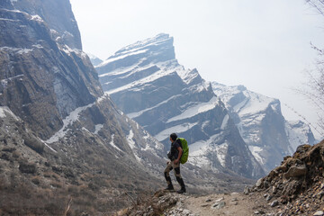 Young asian male hiker carrying mountain backpack and using trekking pole took photos after...