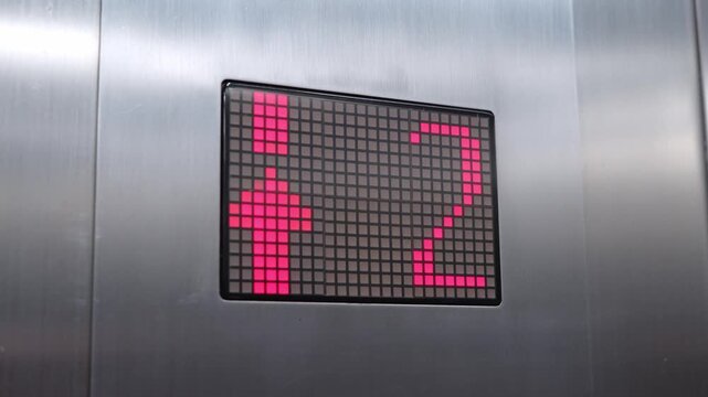 elevator digital display showing arrow red light number going up from first floor in office building