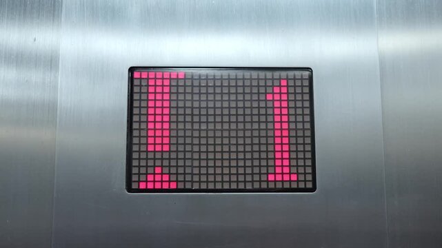 elevator digital display showing arrow red light number going up from first floor in office building