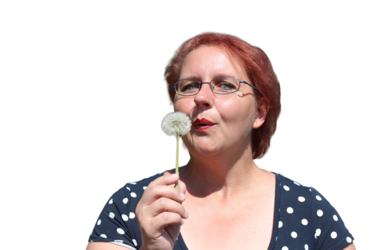 Red-haired woman with dandelion in her hands on the nature	
