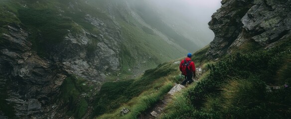 The hiker navigating a misty mountain trail amid lush greenery and rocky terrains.