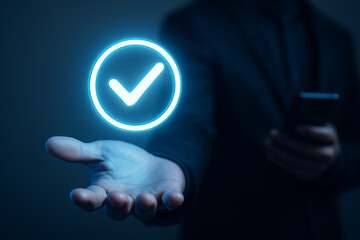 Businessman holding glowing check mark verification icon representing successful digital approval in secure online access and mobile authentication system