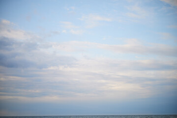 Obraz premium Calm sea under cloudy sky at sunset time