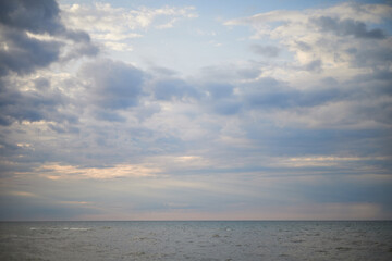 Obraz premium Calm sea under cloudy sky at sunset time