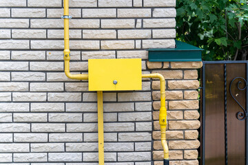 Yellow gas distribution box and pipes supplying a residential building