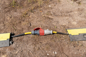 Power cable connector lying on ground with cable protector providing safety
