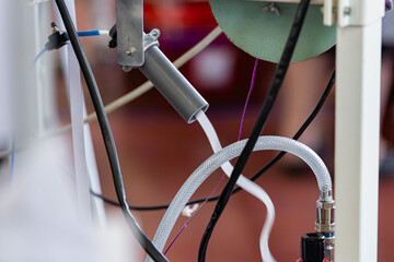 Zoom sur une partie d’une machine à coudre révélant les fils électriques, mettant en évidence les connexions techniques nécessaires à son fonctionnement.