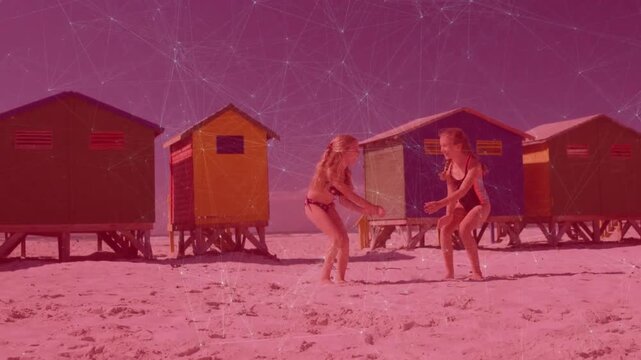 Upon raising arms by beach huts sisters jumping three times, stepping apart gesturing for health