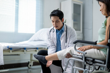 Obraz premium A doctor is examining a woman's leg in a hospital room