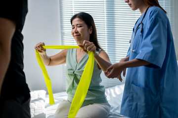A woman is being assisted by a nurse in a hospital room