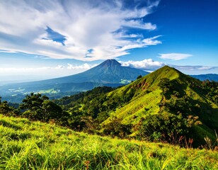 Lush green hills meet a volcanic peak under a vibrant sky