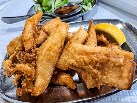 Famous O Rei do choco frito in Setubal, Portugal. Fried squid and octopus served with french fries and salad.