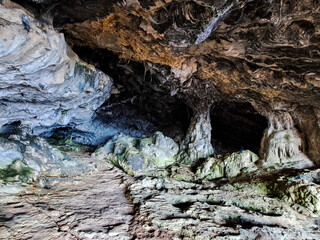 Dark interior of Lapa de Santa Margarida in Arrabida, Setubal, Portugal. Cave with small chapel of spontaneous worship
