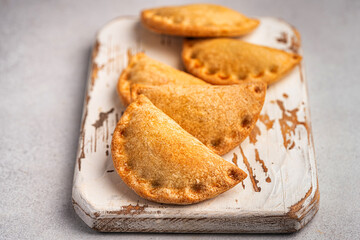 Traditional baked Spanish empanadas savory pastries with meat stuffing or vegetables against white background, fresh and homemade. Latin food.