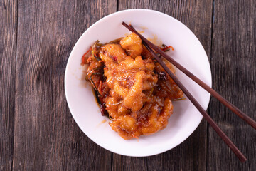 Fried chicken pieces in a sweet and spicy sauce on wooden background. Chinese food. Asian cuisine