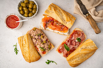 Variety of sandwiches with tuna, salmon y jamon or prosciutto for breakfast on white background, top view, Bruschetta snacks for wine.
