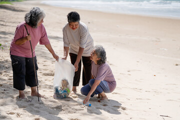 A group of older people are picking up trash on the beach to help keep nature clean and beautiful.