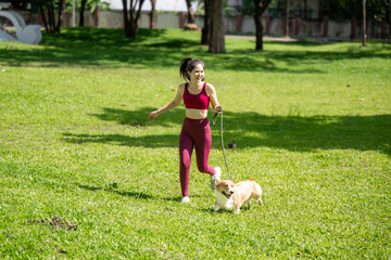A woman is walking her dog in a park