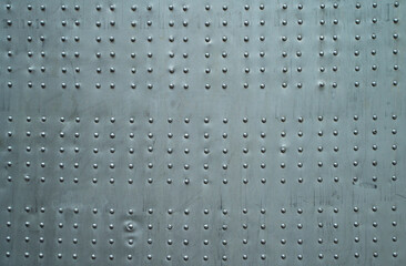 Abstract metal background. Old weathered silver metallic background. Vintage metal texture with rivets and bolts. Sheathing old plane. Old metal texture.