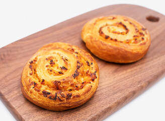 Baked Ham and Cheese Swirls on Wooden Board side view of Savory Pastries