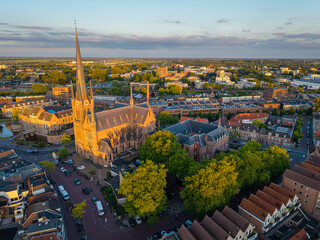 Naklejka premium Aerial cityscape of Woerden, The Netherlands, featuring historical St. Bonaventura church at sunset