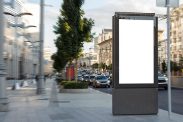 Vertical billboard near the road in the city. Granite pavement, traffic jam. Mock-up.