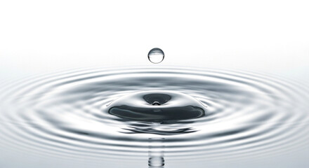 Water drop creating ripples, isolated on white