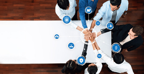 A diverse group of professionals engaged in teamwork over a conference table, emphasizing the importance of collaboration and security in the modern digital workspace. Amity