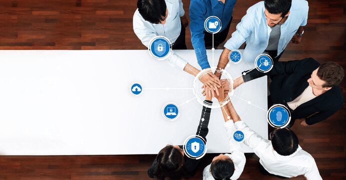 A diverse group of professionals engaged in teamwork over a conference table, emphasizing the importance of collaboration and security in the modern digital workspace. Amity
