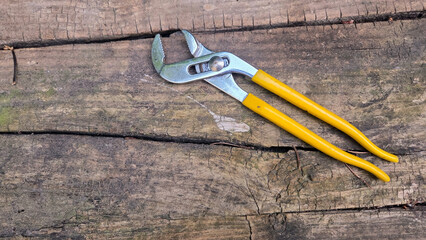 Plumber's adjustable wrench on wooden surface for home repair and maintenance. Pipe wrench, Swedish wrench. Horizontal banner. Copy space