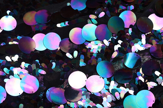 Black sequin fabric with large holographic paillettes—rainbow oil-slick shine ideal for fashion, party styling, textiles, sparkle couture, dancewear, and festive glam backgrounds.
