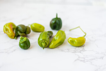 Green peppers on marble background ready for cooking