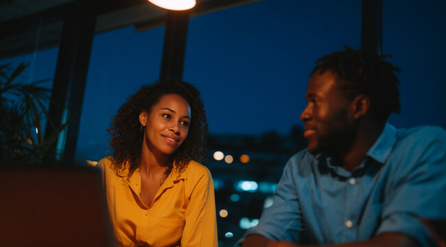 romantic couple working late at office with city view 