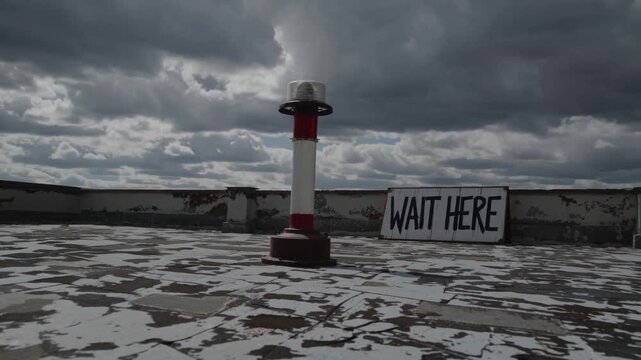 Dark clouds blanket rooftop with a solitary pole and sign urging to wait as storm approaches