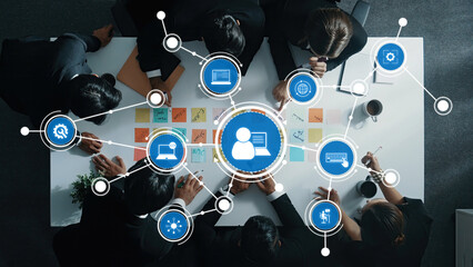 An overhead view of a diverse team in a business meeting, surrounded by digital icons representing technology and innovative concepts, fostering collaboration and strategic planning. Amity