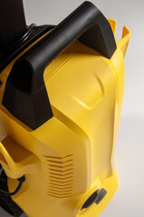 Close-up of a yellow and black pressure washer, highlighting its design and functionality.